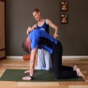 Moriah helps Andrew with back pain in a private yoga therapy class at Yoga 